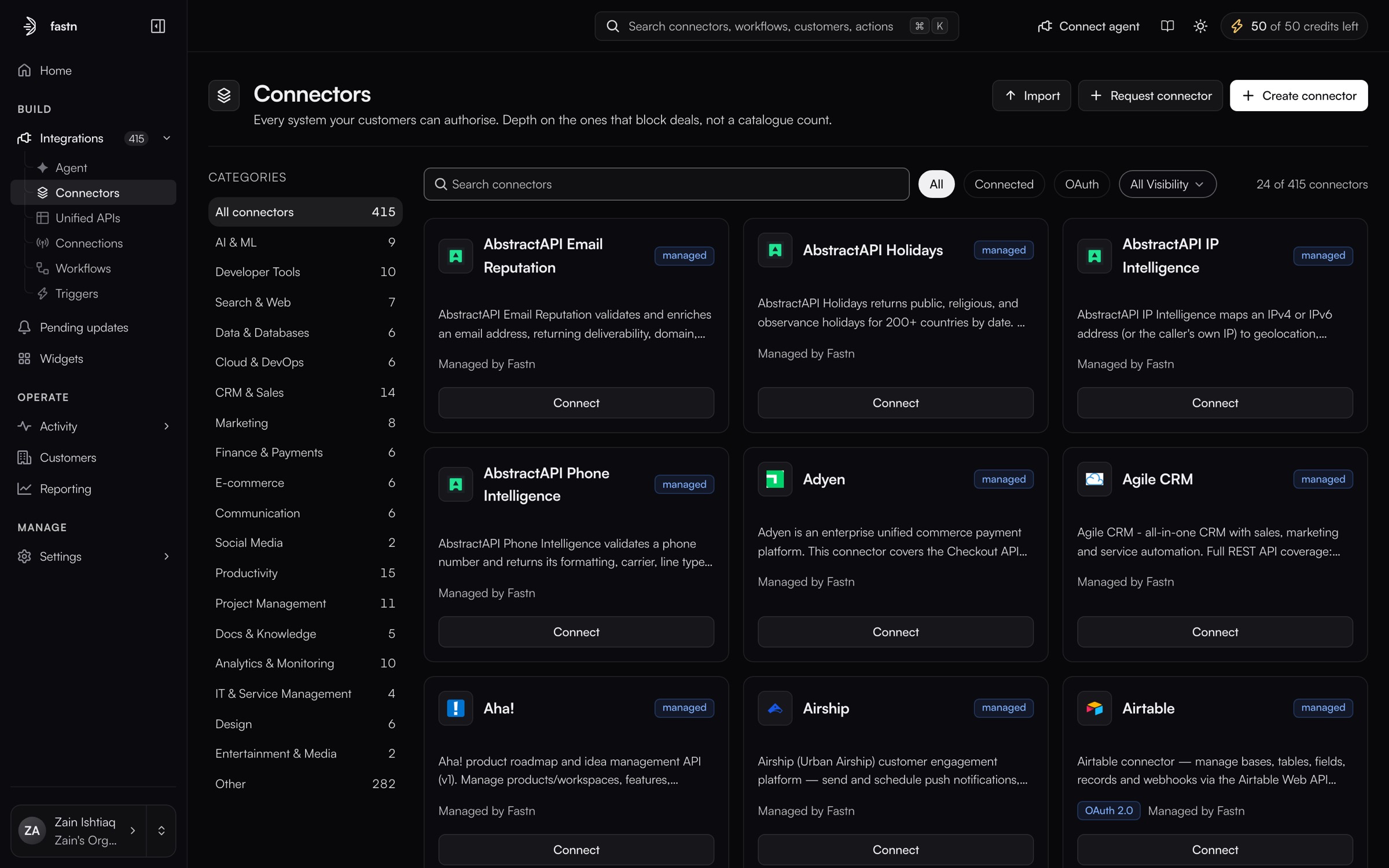 Integrations → Connectors showing 24 of 415 catalogue cards (AbstractAPI Email Reputation, AbstractAPI Holidays, Adyen, Agile CRM, Aha!), each badged managed and Managed by Fastn, with Import and Create connector top-right